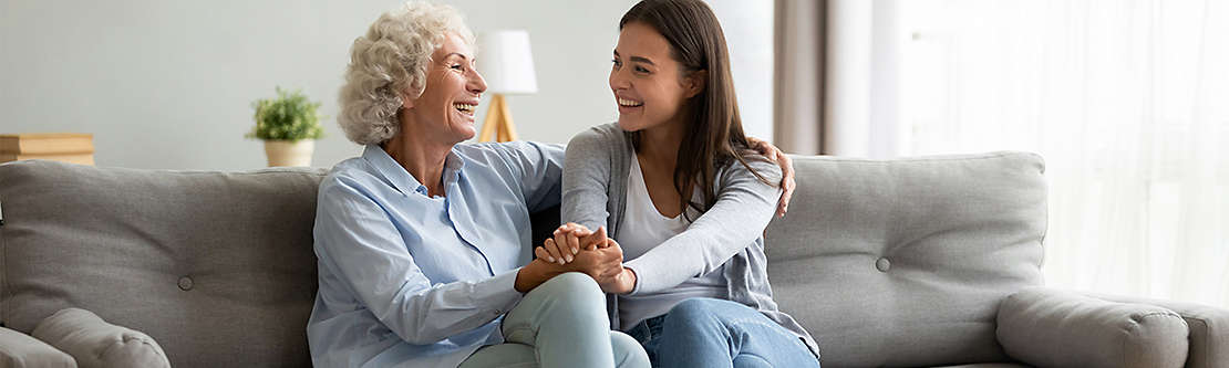 Two women laughing on couch