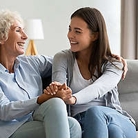 Two women laughing on couch