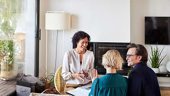 Couple discussing home finance with female advisor