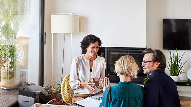 Couple discussing home finance with female advisor