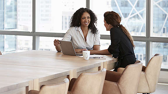 Woman in office chatting with financial services professional about portfolio diversification