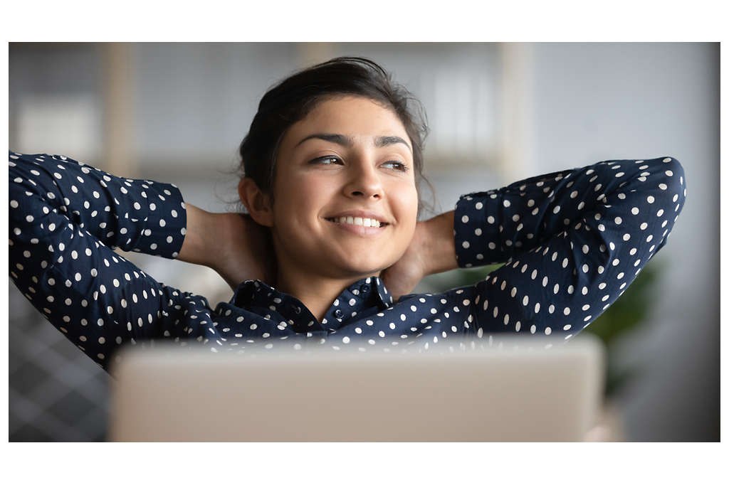 Happy woman with laptop looking out into the distance