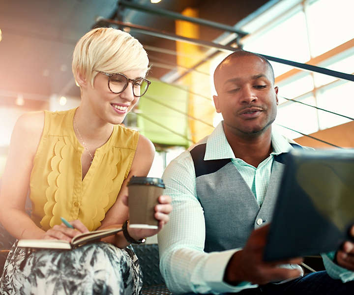 Team of young casual business people collaborating on an online project using a laptop computer in a bright modern office space. 