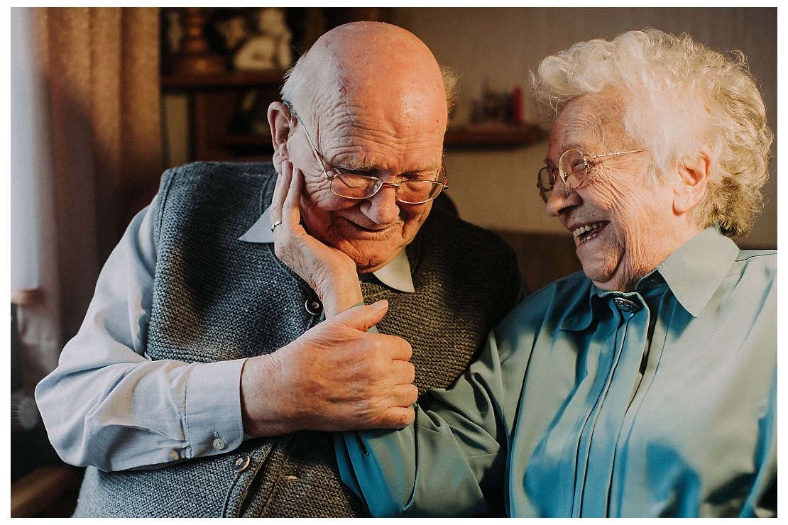 Elderly couple caressing, smiling, and laughing 