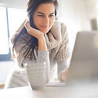 A woman setting up her first online trades on a laptop