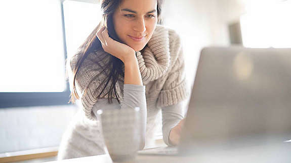A woman setting up her first online trades on a laptop