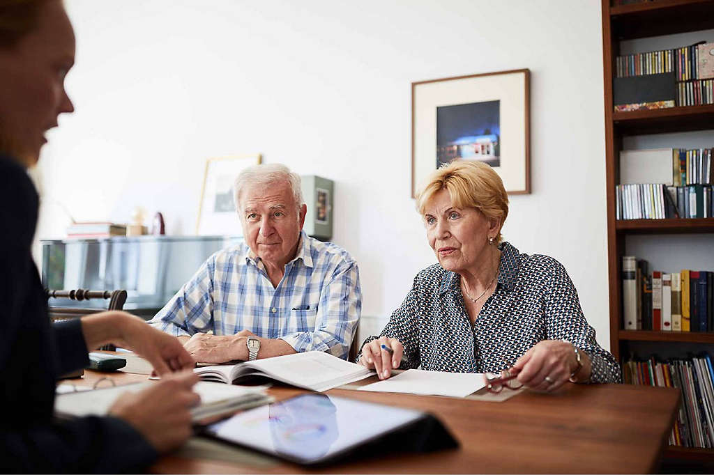 A retired couple discussing their finances with a trusted professional.