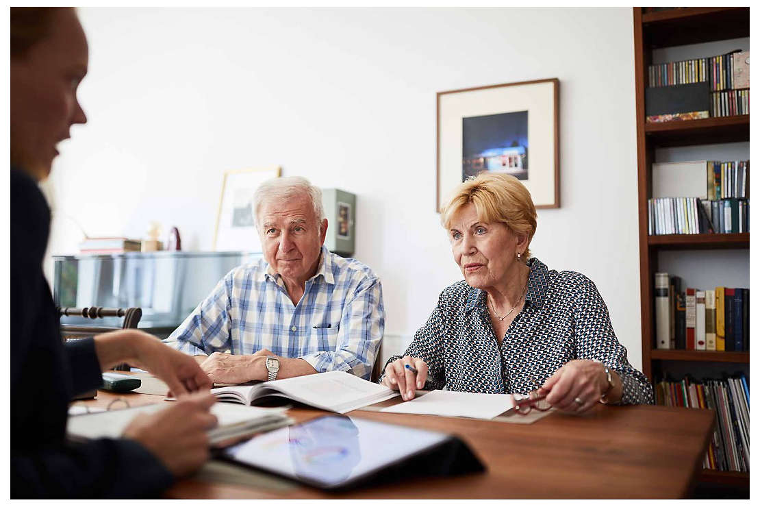 A retired couple discussing their finances with a trusted professional.