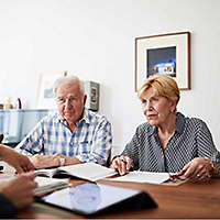A retired couple discussing their finances with a trusted professional.