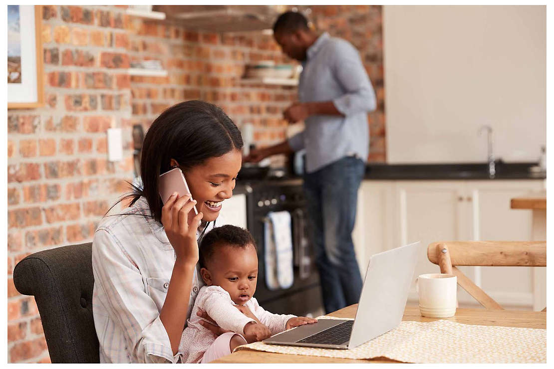 A woman sits with her young child at a computer as she starts a 529 college savings plan with help over the phone from an agent.
