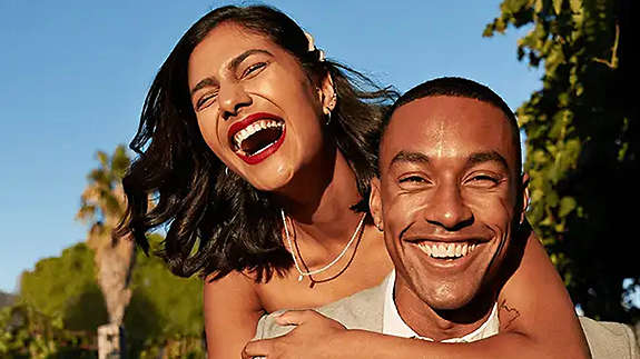 Couple hugging and smiling in park