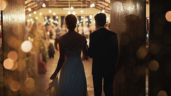 Married couple walking into their reception