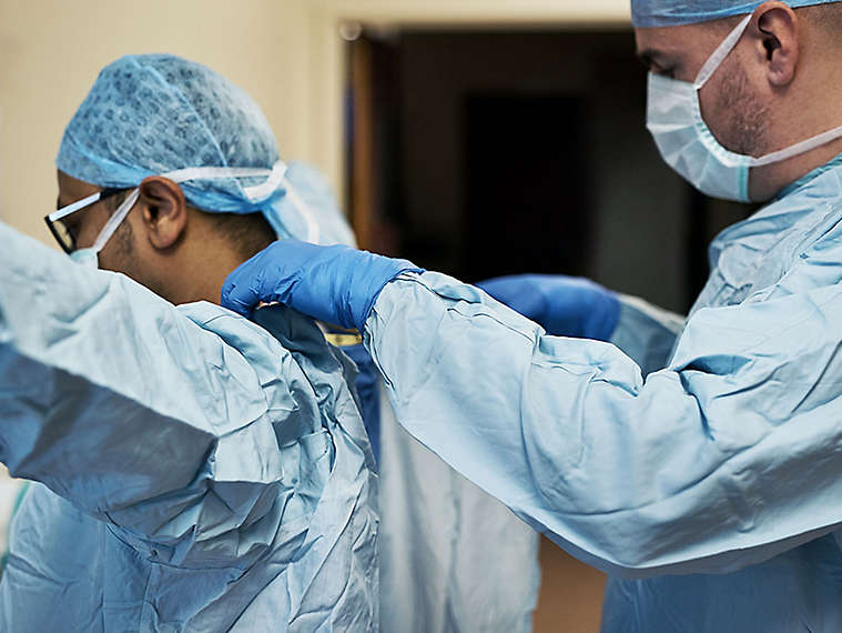 Doctors putting on protective gear.