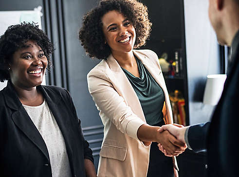 A woman shaking hands with a coworker