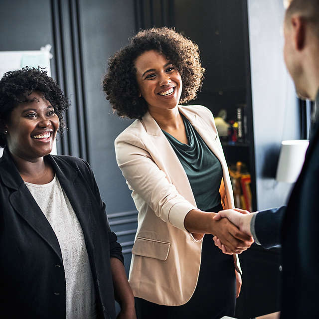 A woman shaking hands with a coworker