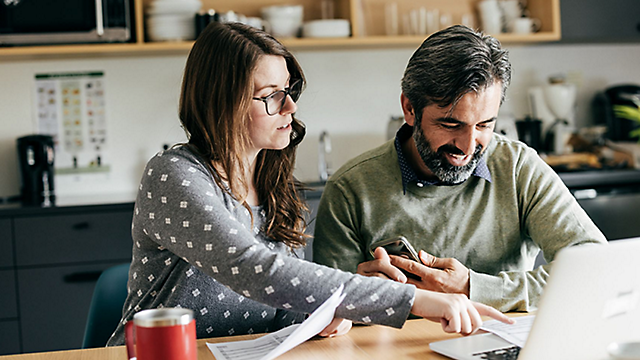 Couple paying bills with a laptop