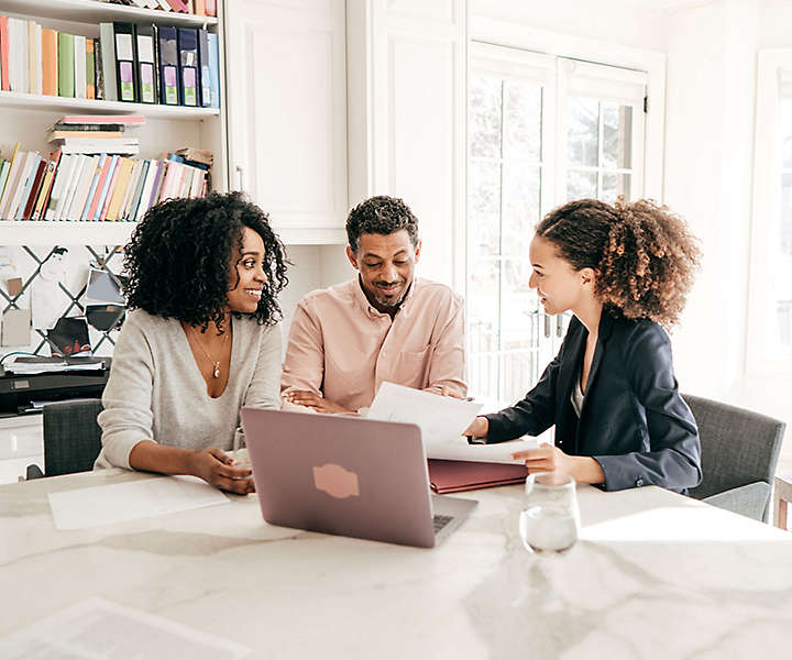 happy-mid-aged-couple-with-agent-in-front-of-laptop