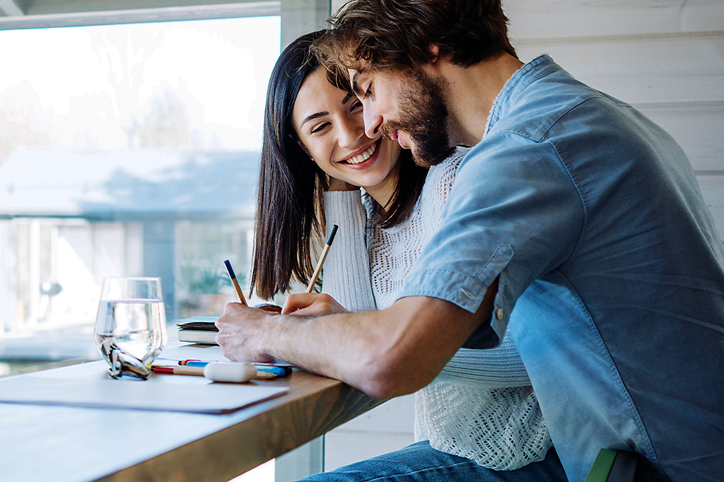 Couple writing down their budgeting plan