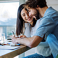 Couple writing down their budgeting plan