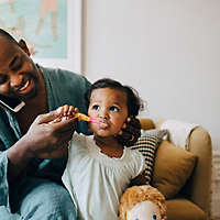 Dad brushing daughters teeth