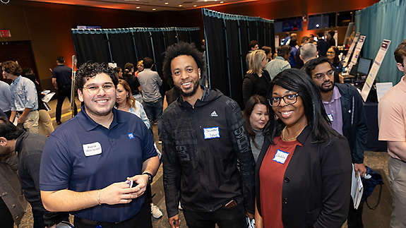 Pedro Velazquez with expo attendees Chris Brown from the Field Operations Value Stream and Shakara Thomas from Corporate Finance.