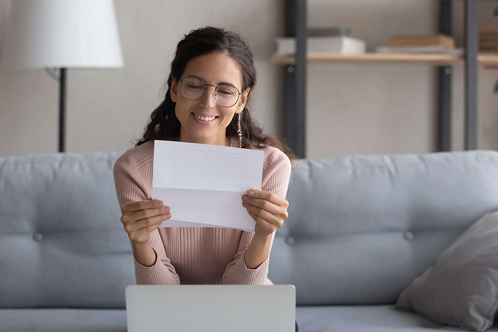  A person looking at a document and smiling