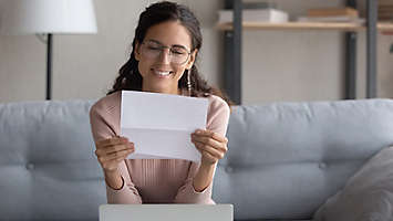  A person looking at a document and smiling
