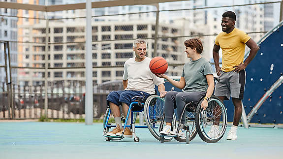 Two people in a wheelchair playing basketball