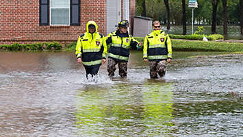Disaster relief workers walking through a flood