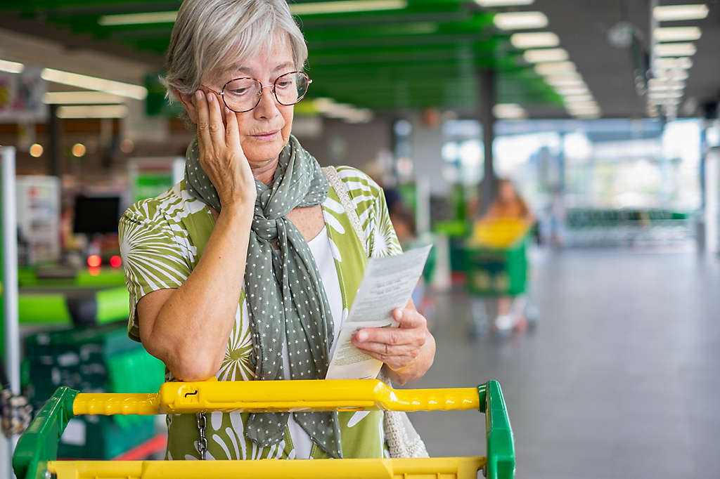 A woman looking at her grocery receipt