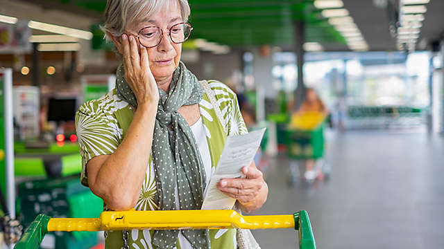 A woman looking at her grocery receipt