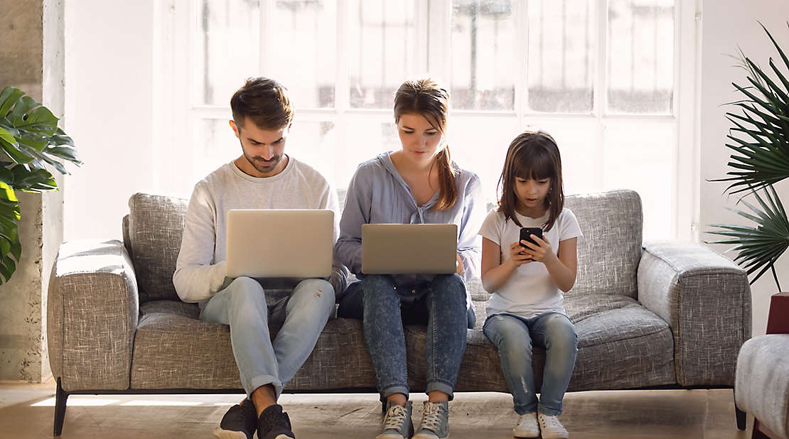 family on couch addicted to technology