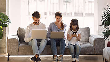 family on computers and phone