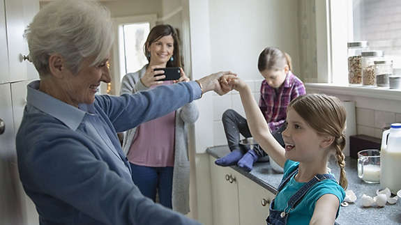 Grandmother and granddaughter dancing in kitchen