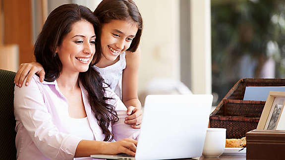 A mother and daughter looking at a laptop