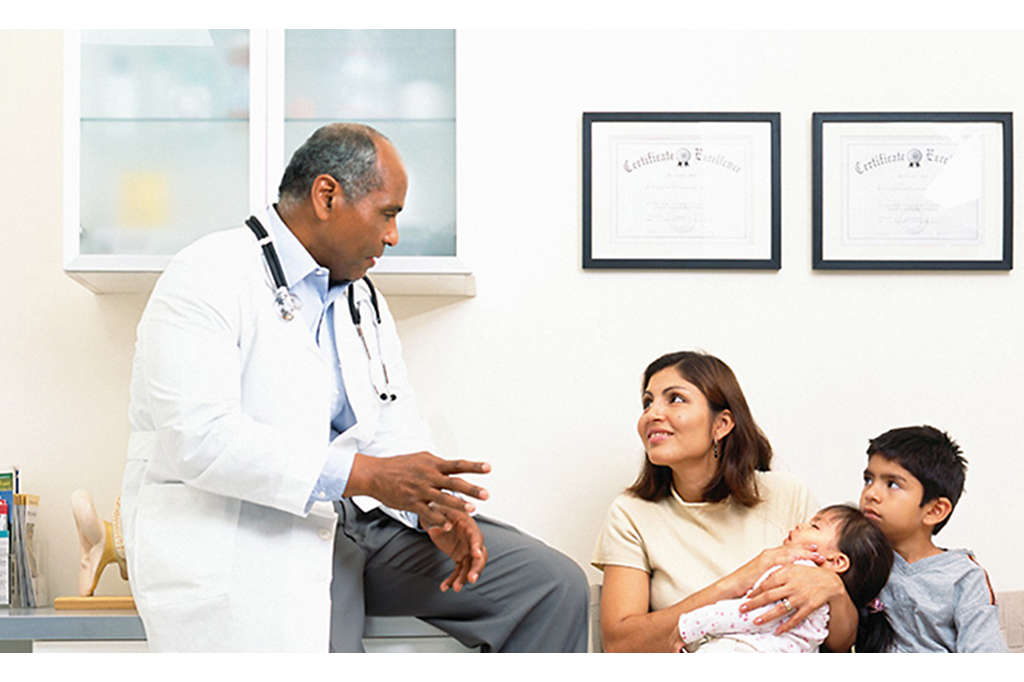 Mother and children speaking to a doctor at a doctor's office