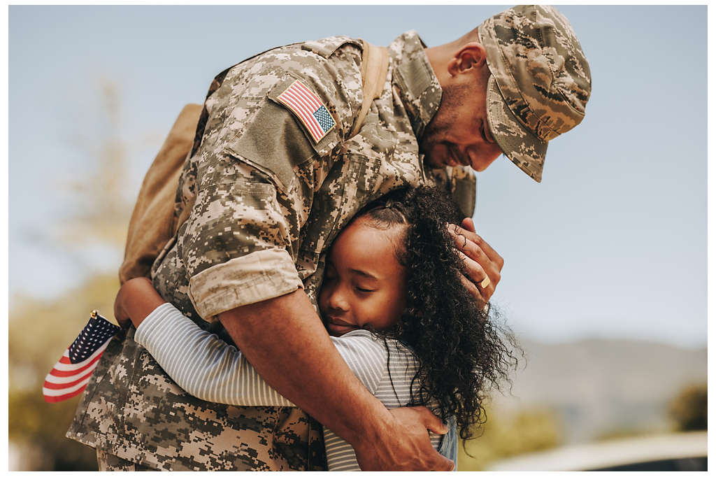 A military father hugging his daughter