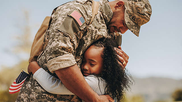 A military father hugging his daughter