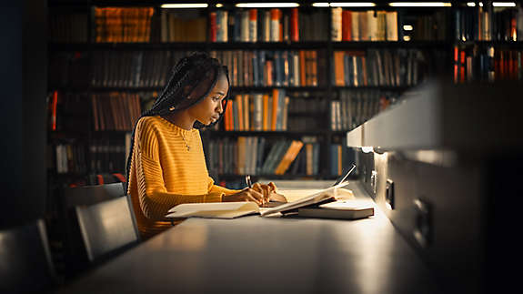 A woman in the library using a laptop