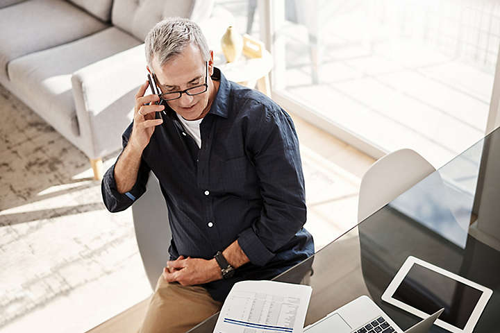 Person talking on the phone at desk.