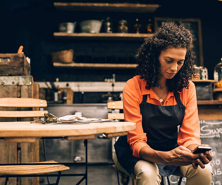 Cafe owner checking phone at a table