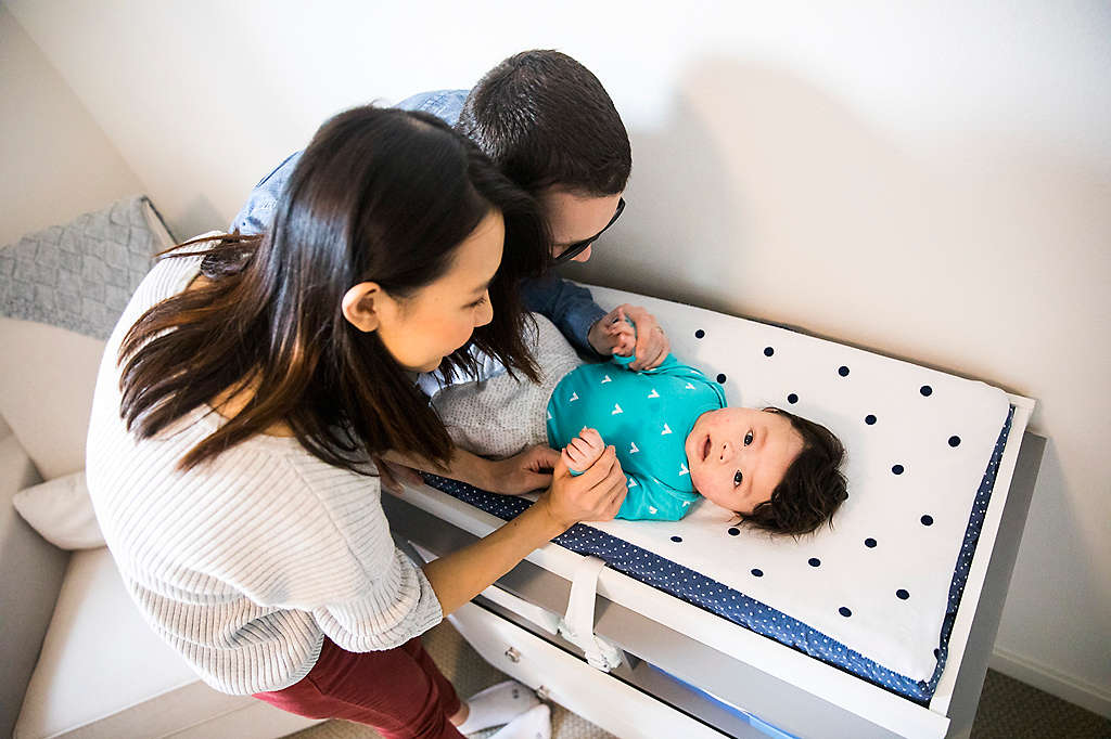 Parents tending to their baby on a changing table.