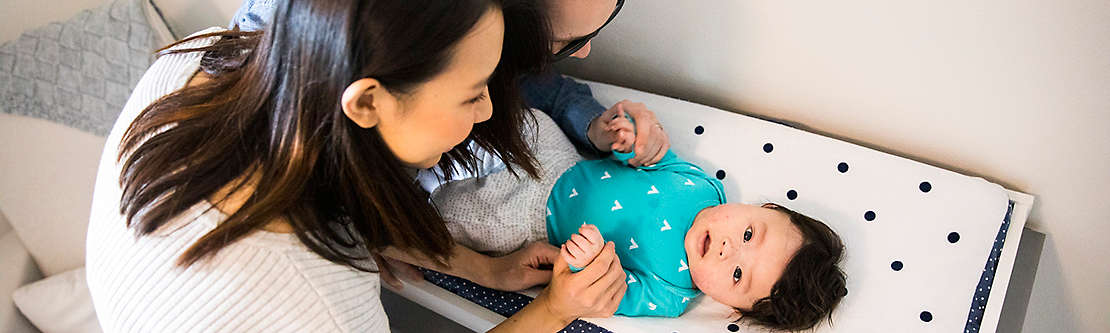 Parents tending to their baby on a changing table.