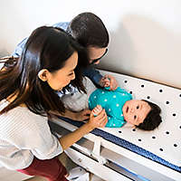 Parents tending to their baby on a changing table.