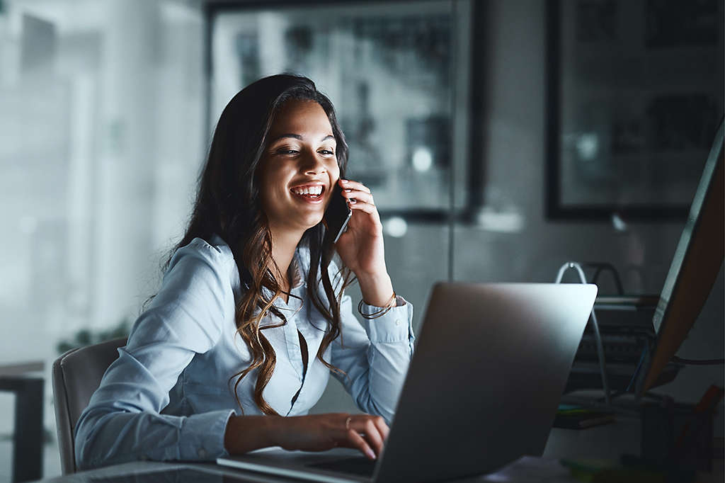 Young women on phone in front of laptop