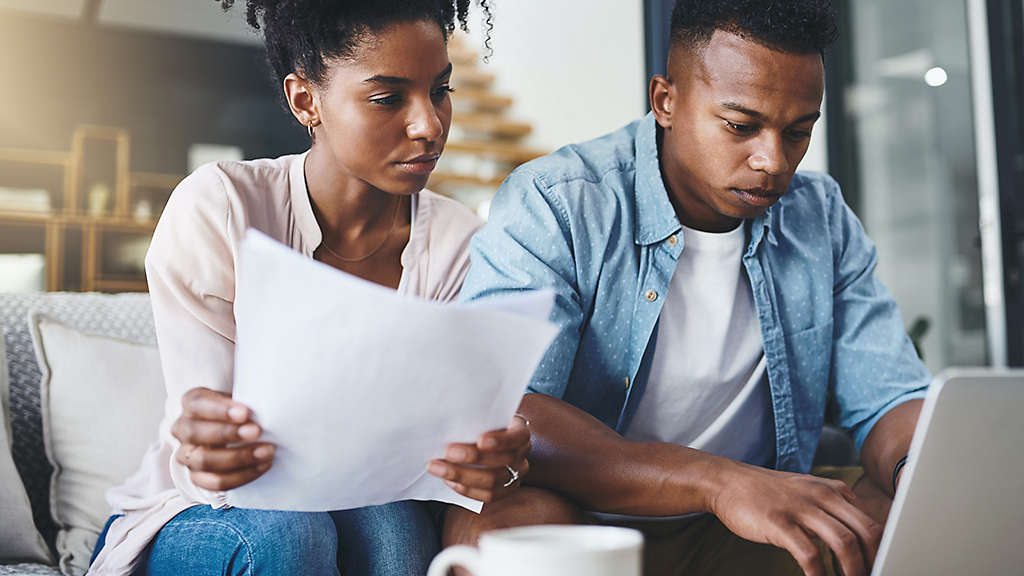 Couple reviewing paperwork in their home.