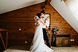 Bride and groom hugging and kissing indoors.