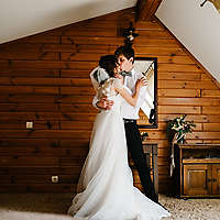 Bride and groom hugging and kissing indoors.