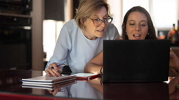 A parent and child working on laptop