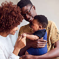 A young couple holding their baby.